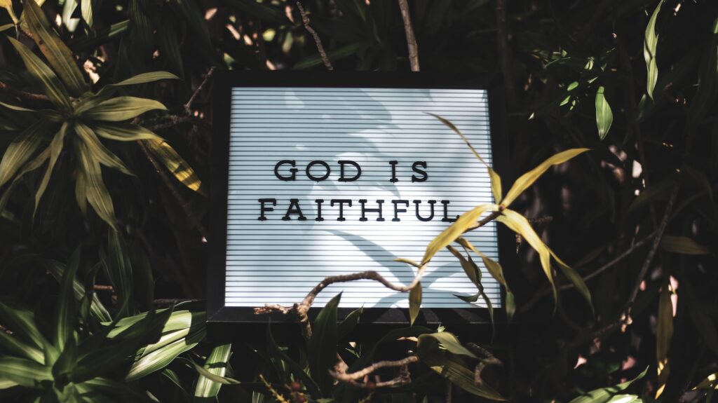 Love: God is Faithful signage with leaved background