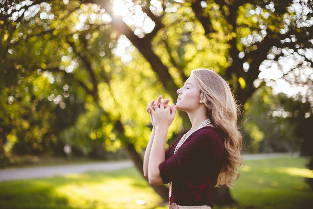 consistent prayer life: woman praying under tree during daytime