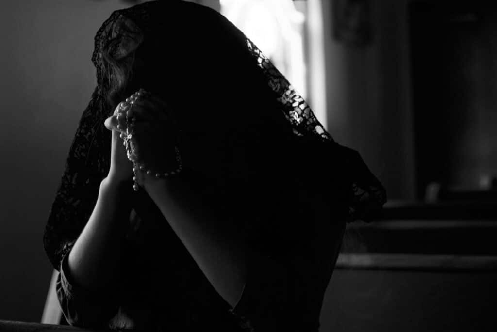 Hope in Salvation: grayscale photography of woman praying while holding prayer beads