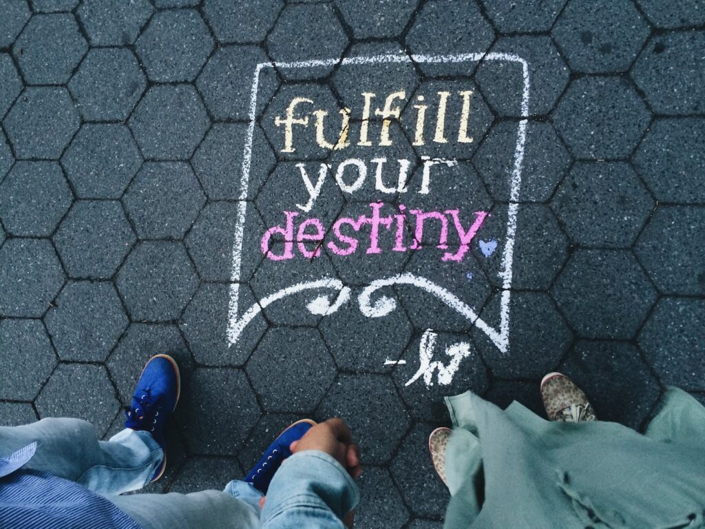 finding purpose - two person standing on fulfill your destiny pavement artwork