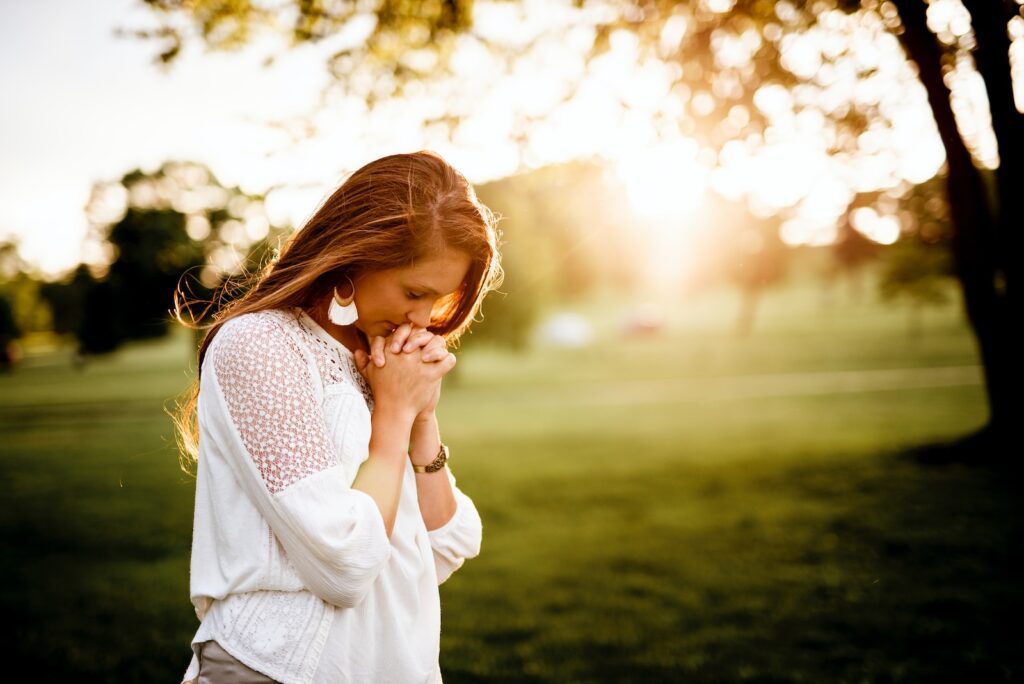 Transformative Power of Hope: woman praying beside tree