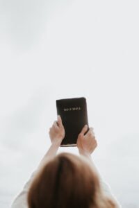 person holding Holy Bible - faith in crisis