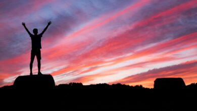silhouette of man standing on high ground under red and blue skies - Spirit-Filled Transformation