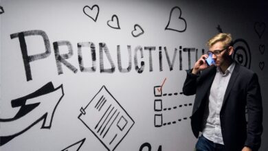 man holding smartphone looking at productivity wall decor - Productivity tips