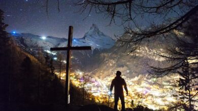 man standing near cross during night - what was the purpose of Jesus death on the cross